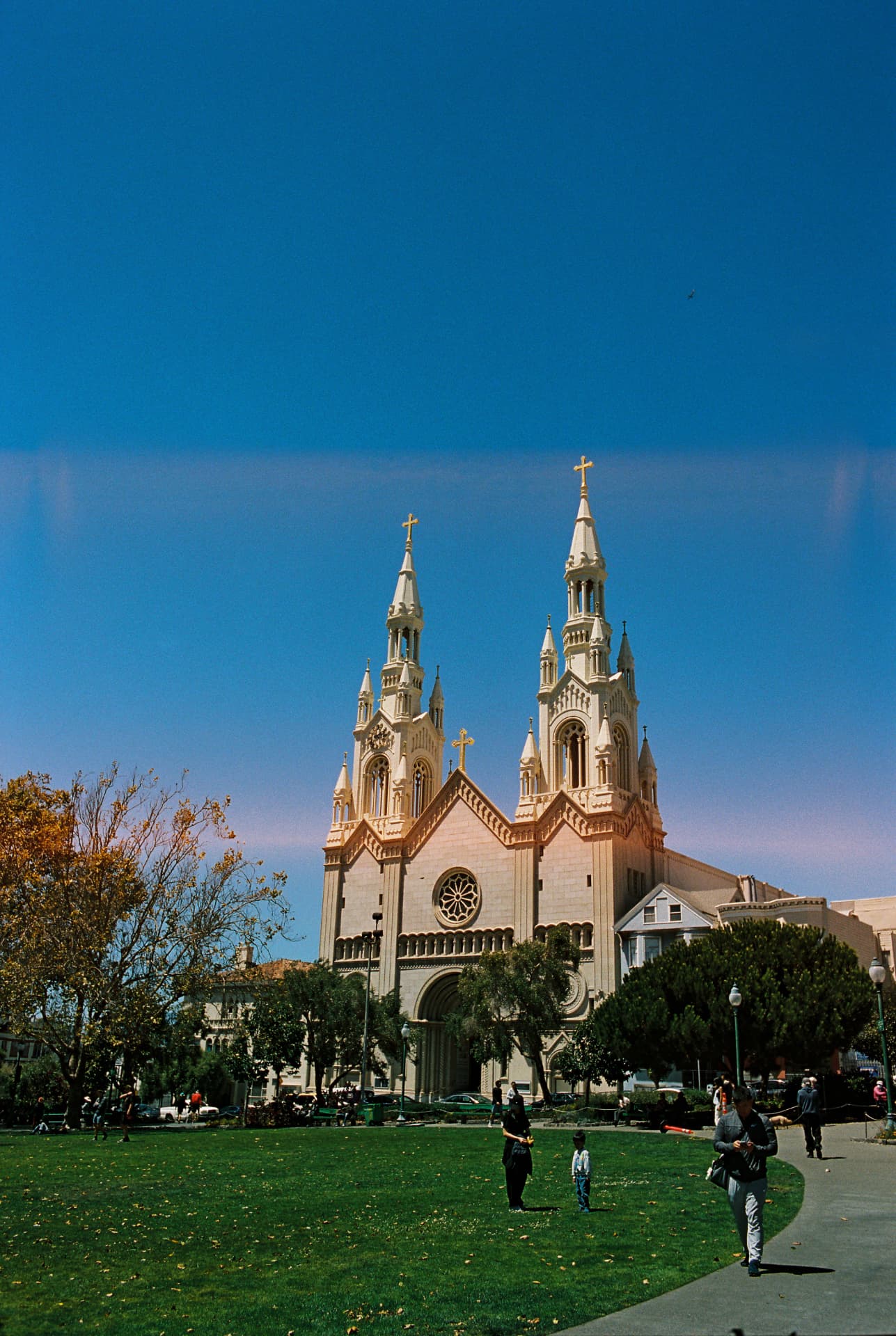 Twin church spires against a deep blue sky