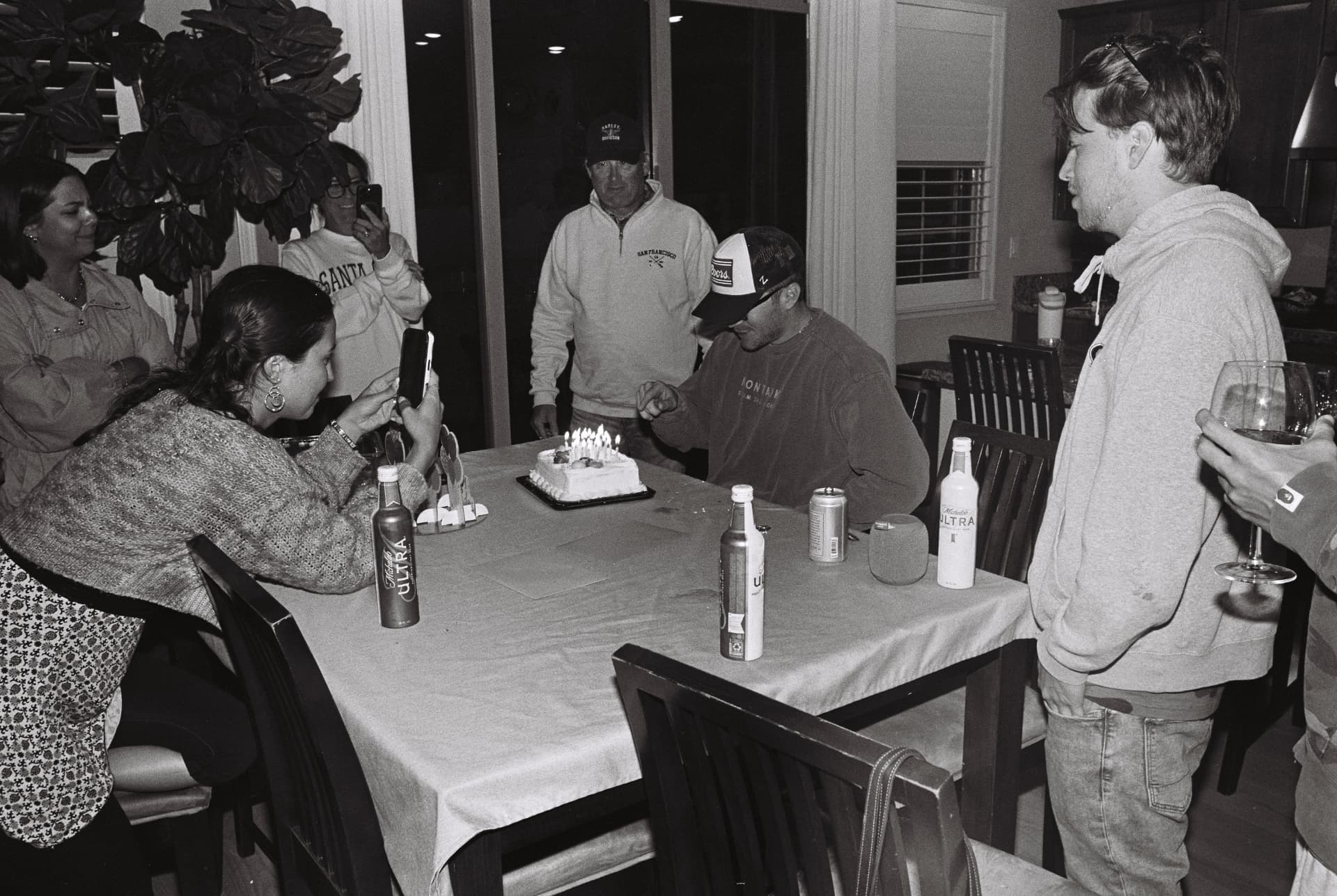 Black-and-white photograph of friends gathered around a table