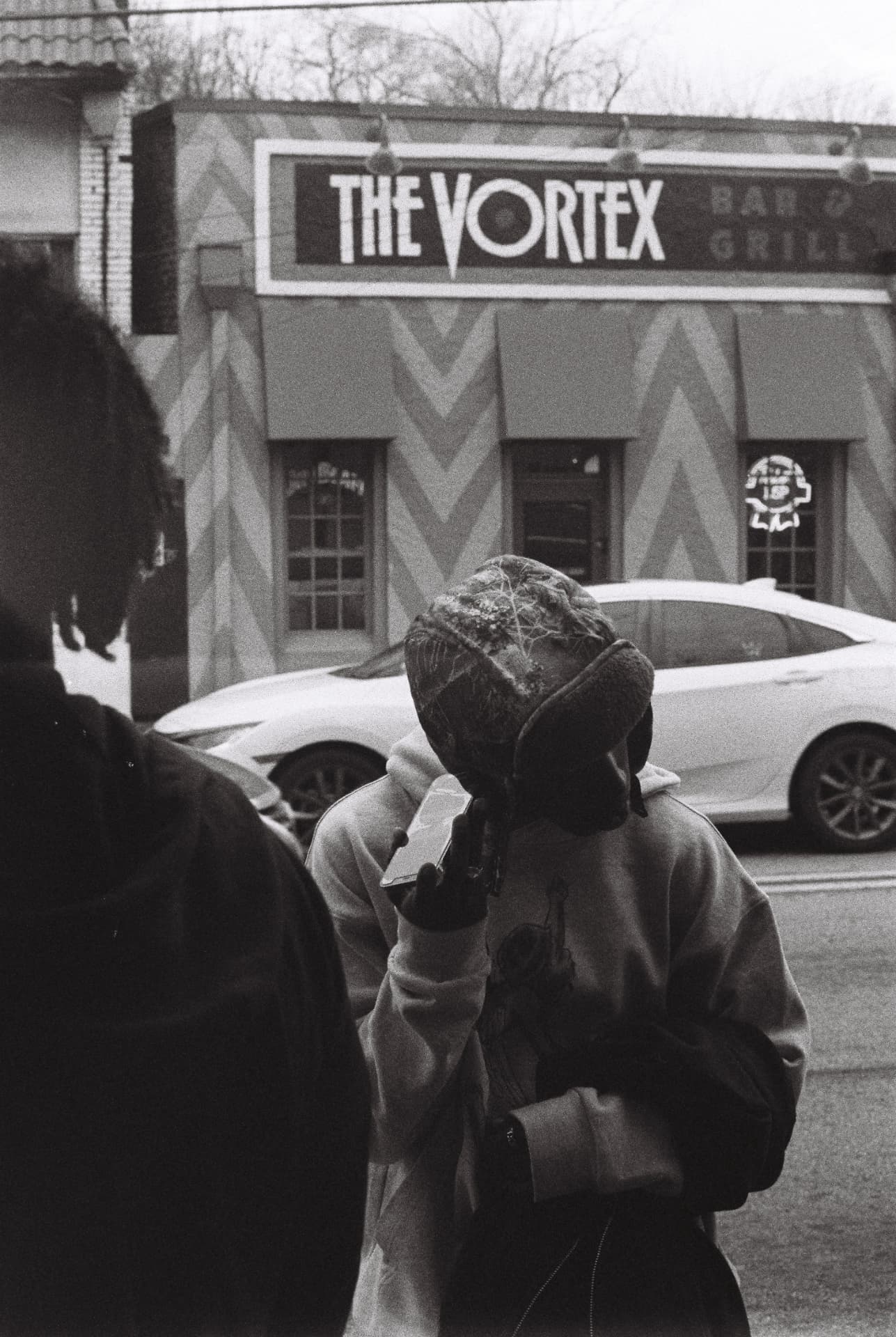 Black-and-white photograph of people outside The Vortex