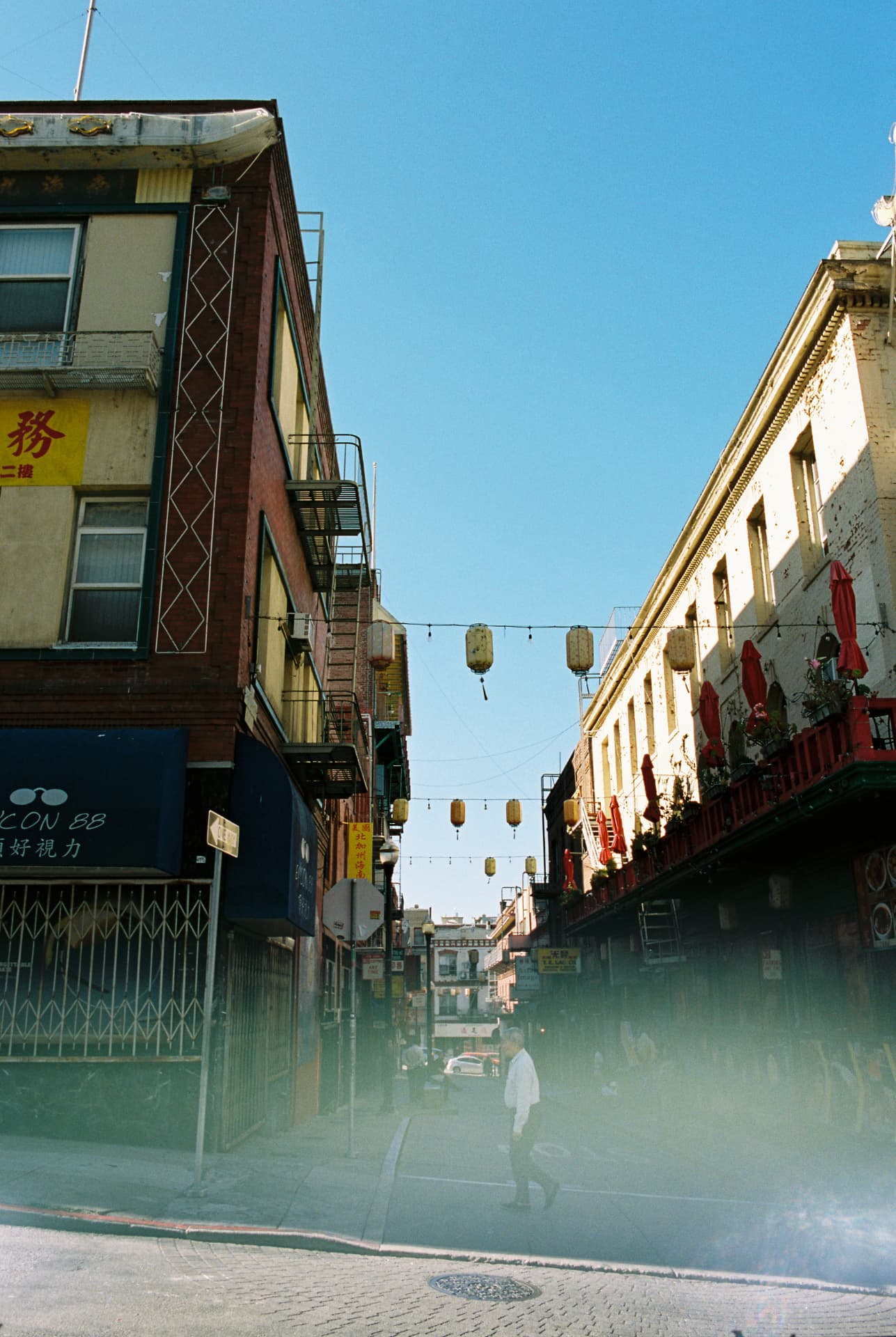 Lanterns suspended above a sunlit Chinatown street